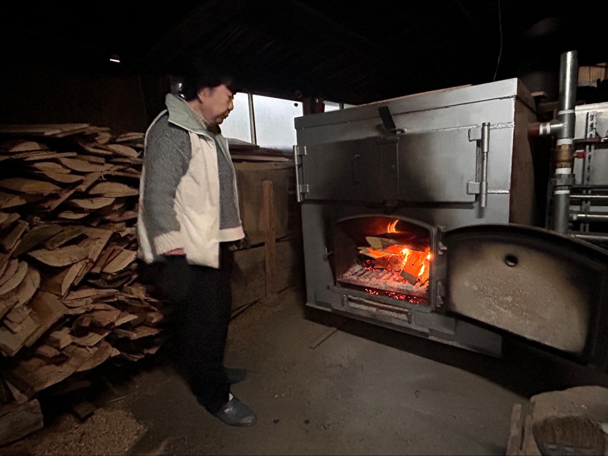金平湯で薪を焚べる様子